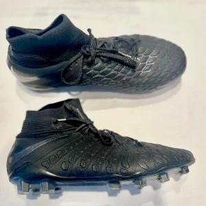 NIKE HYPERVENOM 3 ELITE DF FG STEALTH OPS - SVART - Snygga svarta fotbollsskor med snörning och en texturerad yta för bättre grepp. Svårt att få tag på dessa skor nu, kom med ett pris och vi kan diskutera. De har ett litet hål därför e så billiga