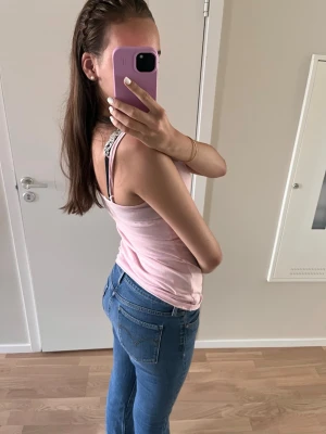 Levi's blå bootcut jeans - Klassiska blå jeans från Levi's med bootcut-modell och fem fickor. Jeansen har den ikoniska röda Levi's-lappen på bakfickan och patch i läder bak i midjan. Tillverkade i slitstark denim med snygga slitningar och kontrastsömmar. Lite slitage längst nere på kanterna (bild 4) men är annars i bra skick!💗