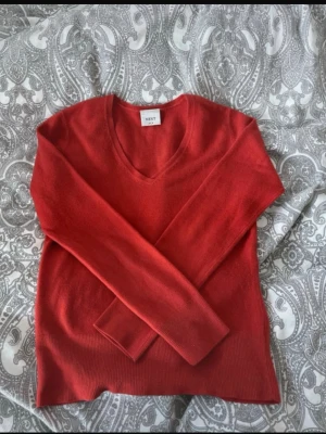 Orange stickad tröja med V-ringning - Snygg orange stickad tröja från Next med V-ringad hals och långa ärmar. Tröjan har ribbade muddar vid ärmslut och nederkant, vilket ger en stilren look. Perfekt för att hålla värmen under kyliga dagar. Lite smått nopprig vilket syns på bilderna. Storlek uk 10 men passar mig som har S.