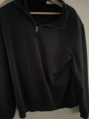 Svart halvzip hoodie - Svart half zip hoodie, lite tjockare perfekt för vintern, storlek m, helt nytt aldrig andvänd säljes för de inte riktigt va min stil, nytt 200 mitt 150. 