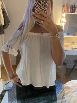 Vit offshoulder blus med volang - Söt vit offshoulder blus med korta ärmar och volang, lite trasig på en arm men inget man lägger märke till