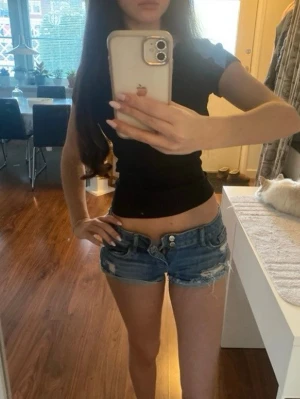 Lågmidjade blå jeansshorts med revor och fransar - Snygga low waist jeansshorts i strl 34, midja 38cm. Kommer lägga upp fler liknande plagg så följ!