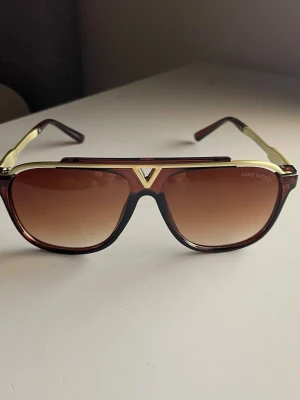 Solglasögon  - Uppgradera din stil och skydda dina ögon på samma gång. Med en tidlös design, fjäderlätt passform och fullt UV-skydd är dessa solglasögon det enda tillbehöret du behöver i sommar. Säkra din stil och klicka hem dina nya favoriter idag! 🌟 