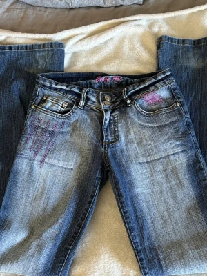 Crazy age jeans storlek XS - Low waist bootcut jeans. Mörkblåa med coola och unika rosa detaljer. Varan är i fint skick💗