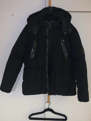 Xs Vinterjacka Closure London Svart   - Säljer den pågrund av har fått en ny boss jacka behöver inte 2 jackor räcker med en dragkedjan har gått av på höger bröst nån som kan om textil kan fixa lätt totalt annars totalt 5 fickor Snygg svart dunjacka från Closure London med huva och två snedställda bröstfickor med dragkedja. Jackan har hög krage och justerbar huva, perfekt för kalla vinterdagar. Modern och stilren design som passar till det mesta.