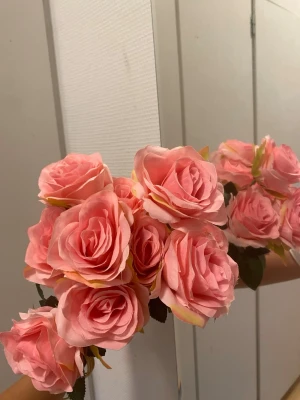 Två buketter konstgjorda rosor - Säljer två buketter med konstgjorda rosor, en med ljusrosa blommor och en med ljusblå. Blommorna är gjorda i tyg och har gröna blad. Perfekt som dekoration till rummet eller till pysselprojekt.