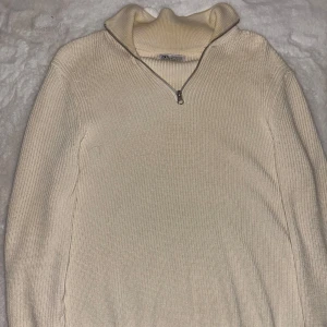 Beige ribbad stickad tröja från Zara - Säljer en beige stickad tröja från Zara med ribbad struktur och hög krage. Tröjan har en snygg half zip-dragkedja framtill och långa ärmar. ✅ Nypris: 599 kr. Testat två gånger och aldrig använt utomhus. 
