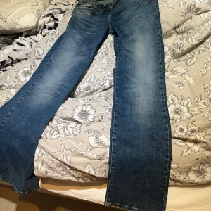 Blå bootcut jeans från LTB - Snygga blå jeans från LTB, modell Valerie, med klassisk bootcut och coola kontrastsömmar. Jeansen har fem fickor och en lätt tvättad look som ger en avslappnad vibe. Perfekta för dig som gillar en tidlös och bekväm stil.