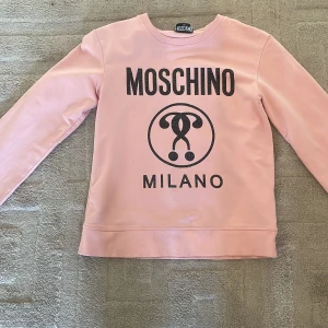 Rosa Moschino tjock tröja med diamant text - En jätte snygg tjock tröja från moschino. Säljer den då den är för liten, använd några gånger. Köpte för 1000kr