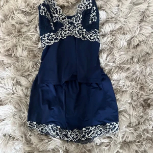 Mörkblå pyjamas med spetsdetaljer - Supersöt mörkblå pyjamas set med vita spetsdetaljer längs bysten och axelbanden. Tunt och mjukt material som känns lyxigt mot huden.