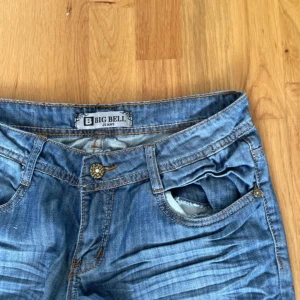 lowwaisted jeans - Snygga blå jeans från Big Bell med klassisk bootcut-passform. Jeansen har låg midja, fem fickor och coola slitningar framtill. Tillverkade i mjukt denimtyg med ljus tvätt och detaljerade sömmar. Perfekta för en avslappnad och trendig look. 