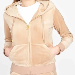 Beige hoodie från Juicy Couture - Supermjuk beige hoodie från Juicy Couture i velour med dragkedja och huva. Använd fåtal gånger. Den är i silver på dragkedjan. Den är S men skulle säga att den passar XS också.