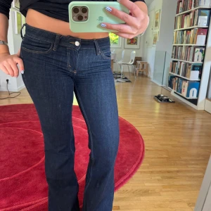 Mörkblå bootcut jeans - Snygga mörkblå jeans med bootcut passform och klassiska fickor. Jeansen har låg midja 