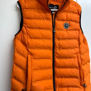 Orange dunväst från Pelle P, stl L - Snygg orange dunväst från Pelle P ❤️ ny och aldrig använd! Köpt för 1500kr
