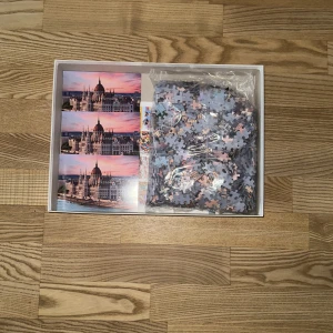 Puzzle 1000: Parliament in Budapest - Utmanande 1000-bitars pussel med en fantastisk bild av det ikoniska parlamentet i Budapest vid solnedgång. Perfekt för dig som gillar resor, arkitektur och att koppla av med en kreativ aktivitet.