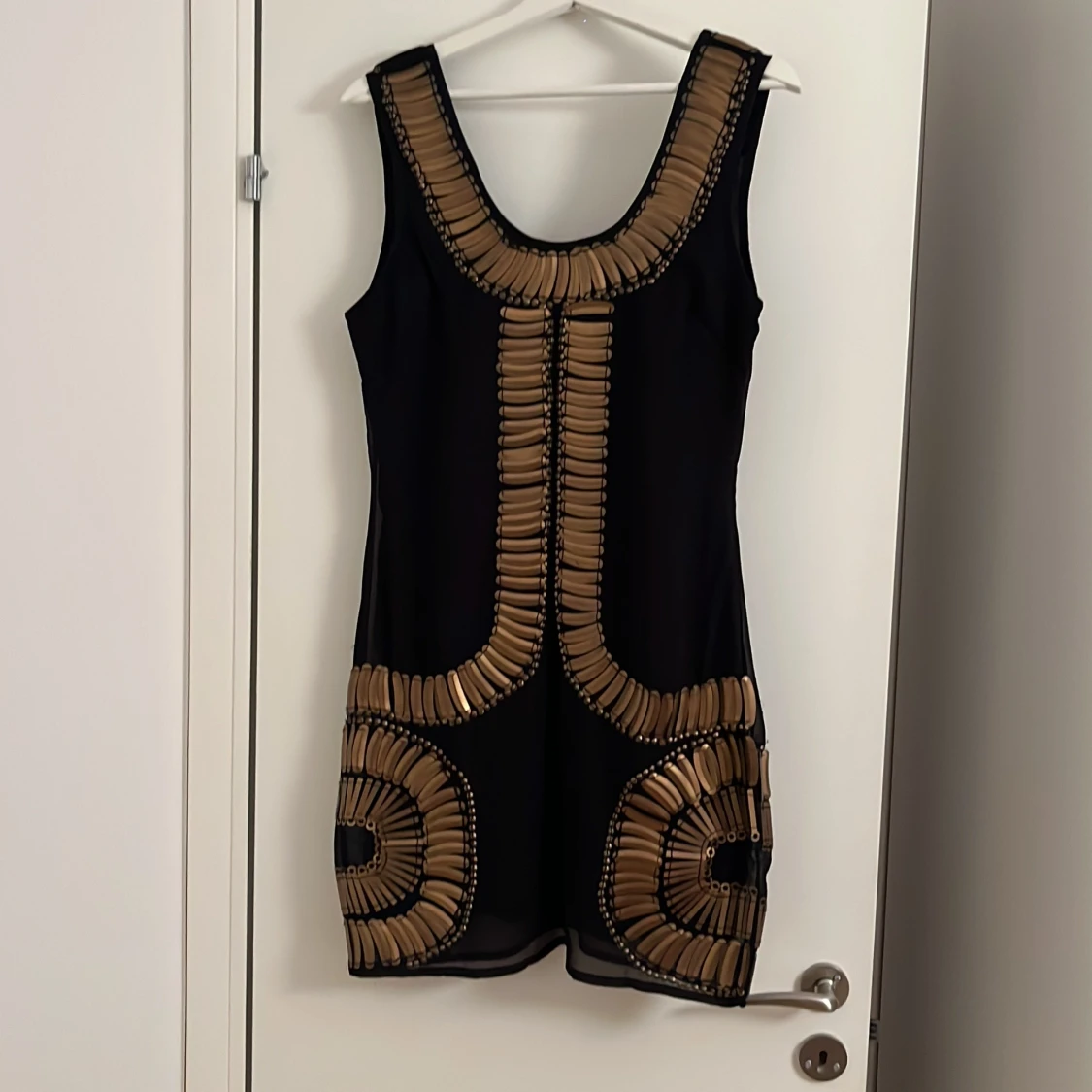 Svart kort klänning med guldmönster