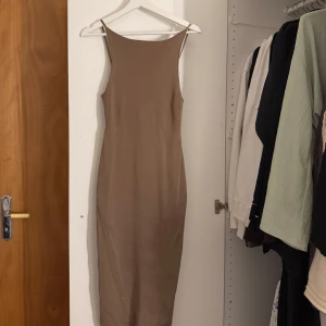 Beige långklänning från Gina Tricot - Brun klänning från Gina Tricot med låg/öppen rygg, använd få gånger. Figursydd/ tight. 