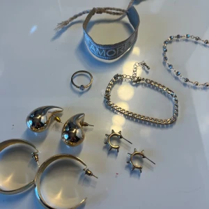Smyckes kit - Säljer ett set med flera smycken: två par stora guldiga örhängen, ett par mindre örhängen med taggar, ett par droppformade örhängen, en tunn ring, ett armband, ett pärlarmband och ett tygarmband☺️☺️allt är i guld! Måste få bort massa saker så säljer endast i kit!
