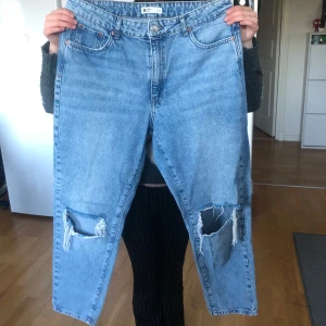Ljusblå jeansbyxor från gina tricot - Ljusblå jeansbyxor med raka ben och stora slitningar på båda knäna. High waist och helt oanvända! Köpte för några år sedan, men använde aldrig de så tänker sälja de!💓 skriv vid frågor och funderingar🌟köpta för 450kr