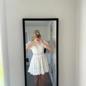 Vit klänning från By Malina - Säljer en  vit klänning från By Malina i storlek XL(Jag brukar ha storlek 40 eller L så liten i storleken ). Klänningen har korta puffärmar och vackra spetsdetaljer. Klänningen är endast använd en gång och är i mycket bra skick! Nypris 2500kr mitt pris 900kr