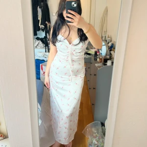 Sommarklänning med små blommor  - Korsad i ryggen, använd en gång, inte alls genomskinlig. Perfekt för midsommar! M men passar även mig med S. Beror väll på hur man vill att den sitter. Inga fläckar eller defekter alls. 