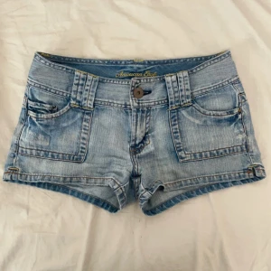 Ljusblå jeansshorts från American Eagle - Snygga ljusblå jeansshorts från American Eagle det saknas en knapp på ena bakfickan. Men om man till exempel har telefonen där så märks det inte! Dom är tyvärr försmå för mig💕 skulle säga en liten s / stor xs