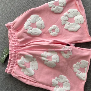 Denim tears shorts - Säljer ett par rosa shorts från Denim Tears med vita, upphöjda molnliknande mönster. Skick 10/10, helt nya, hör av er vid intresse av köp!😃