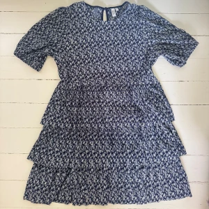 💙🤍Blommig klänning från & Other Stories - Supersöt blommig klänning från & Other Stories i marinblått och vitt. Klänningen har korta ärmar, volangdetaljer och en luftig passform. Perfekt för vår och sommar!! Så snygg till ett par ballerinas, sneakers eller klackar❤️‍🔥❤️‍🔥❤️‍🔥