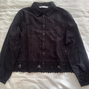 Svart blus med spetsdetaljer - Säljer denna jätte fina svarta blus från Zara. Den har aldrig vart använd då den köptes i fel storlek och vi ej han byta den🥰Passar till väldigt mycket och har fina detaljer i tyget!