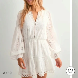 Vit broderad klänning med volang och v-ringning - Superfin vit klänning med broderade detaljer och v-ringning från Nelly. Klänningen har långa, luftiga ärmar och volang nertill. Perfekt för sommaren, endast använd en gång💕storlek 34/xs