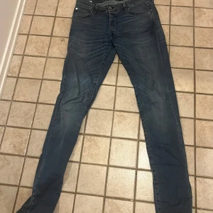 Mörkblå slim fit jeans från Jack & Jones - Snygga mörkblå jeans från Jack & Jones i modellen Slim Fit Glenn. Klassisk femficksdesign, dragkedjegylf och smal passform. Perfekta till vardags för en stilren look. Stolek 32/34