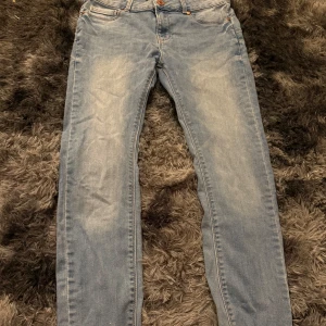 Ljusblå jeansbyxor med raka ben - Säljer ett par klassiska ljusblå jeansbyxor med raka ben och normal passform. har dragkedja och knapp framtill. Perfekta till vardags och lätta att matcha med olika stilar.