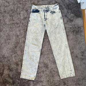 Jeans från Axel Arigato - Snygga acid wash jeans från Axel Arigato i en ljusblå nyans. De har en klassisk femficksdesign och en rak passform. Tillverkade i 100% bomull för en bekväm känsla. Perfekta för en avslappnad stil med en modern twist.