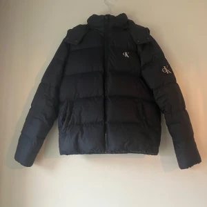 Calvin Klein jacka  - Snygg mörkblå dunjacka från Calvin Klein med huva och dragkedja. Köpt för 2700 på deras hemsida. 9/10 skick