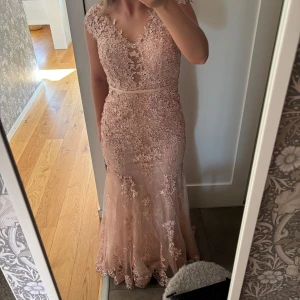 Ljusrosa spetsklänning - Rosa balklänning från dressroom i storlek 2 men passar mig som har vanligtvis storlek 36 eller S. Den är använd en gång och har inga specifika defekter mer än undersidan av släpet (se sista bilden). Nypris är 6500kr och kvitto finns. 