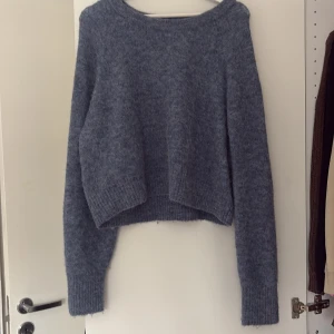 Blå stickad tröja från carin Wester  - Mysig blå stickad tröja från C.W. i storlek S. Tröjan har en enkel design med långa ärmar och en rund halsringning. Perfekt för kyliga dagar.