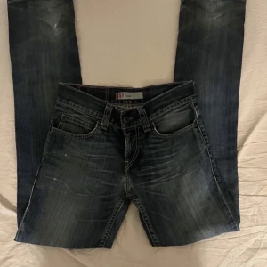 Levis Jeans - Snygga Levis 511 slim jeans i en klassisk blå tvätt. De har en modern slim passform och är tillverkade i slitstarkt denim. Perfekta för en stilren look med fem fickor och knappgylf.