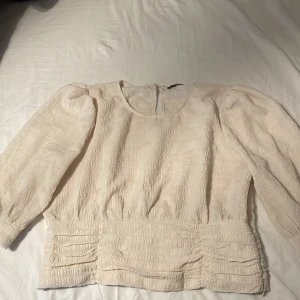 Topp - Tight vid nedre delen, har en gylff vid sidan 