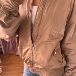 Beige bomberjacka  - Snygg beige bomberjacka från Gina Tricot i storlek XS. Jackan har en dragkedja framtill och ribbade muddar vid ärmslut och nederkant. Mycket bra skick