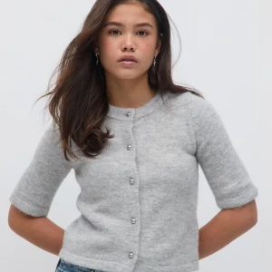 Grå kofta med pärlknappar - Säljer en stilren grå kofta med trekvartsärmar och eleganta pärlknappar. Perfekt för en chic och avslappnad look. Passar bra till både jeans och kjol. Säljer på grund av att den var för stor för mig! Helt ny med prislapp! Skriv privat för egna bilder. 