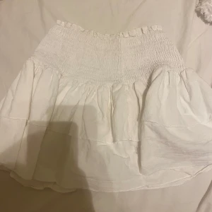 Vit kjol med volang - Kjolen är i storlek 160 med sitter som xs. Super fin till sommaren! 