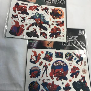 Tillfälliga tatueringar med Spiderman-motiv - Två ark med coola tillfälliga tatueringar av Spiderman i olika actionposer. Perfekt för att ge en superhjälte-touch till din stil. Lätt att applicera och ta bort, idealiskt för fester eller bara för skojs skull. 3 år + 