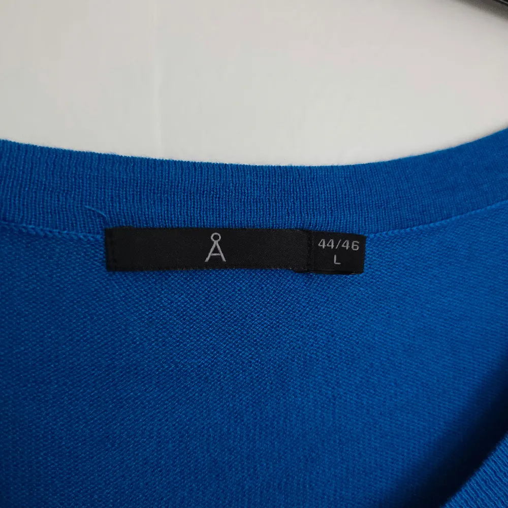 Säljer en snygg blå tröja från Åhléns i storlek L. Tröjan har en v-ringad hals och långa ärmar, perfekt för en stilren look. Den är tillverkad i ett mjukt material som känns skönt mot huden. Passar perfekt till både jeans och kjol. 💙. Neuletakit & Villapaidat.