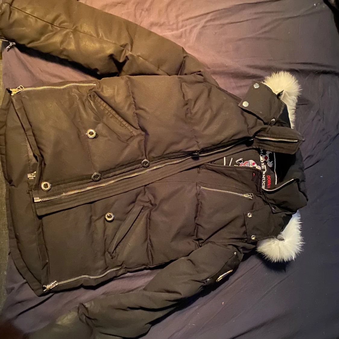 Svart dunjacka med pälsdetaljer