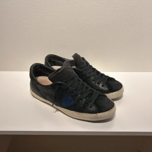 Phillipe Model Skor  - Tja! Säljer ju dessa snygga skor från Phillipe Model. Svarta skor med blå design. Har använts en del så lite slitningar under hälen. Hör av dig vid fundering! 