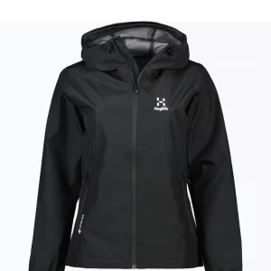 Svart Haglöfs jacka - Snygg och funktionell svart regnjacka från Haglöfs med dragkedja och huva. Perfekt för regniga dagar med sin vattentäta design. Även en vind jacka. Jackan har långa ärmar. Använd 5 ggr precis som ny, en ny kostar runt 2000-3000. Storlek xs passar även mig som s. Pris kan diskuteras. 