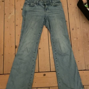 Blå jeans från Gina Tricot - Snygga blå jeans från Gina Tricot med bootcut-stil. De har en klassisk femficksdesign och en låg midja. Perfekta för en avslappnad look. Säljer för de inte passar längre!