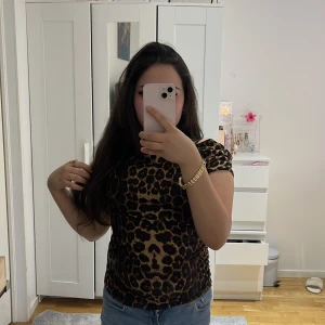 Leopardmönstrad topp - Snygg leopardmönstrad topp med korta ärmar. Perfekt för att ge en djärv touch till din outfit. Tillverkad i ett mjukt och bekvämt material. Jag har haft på mig den ett par gånger men det är inte synligt. Från Shein!