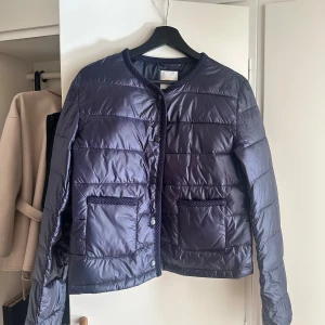 Jacka från Gina tricot - En marinblå jacka från Gina i storlek 170. Passar bra på mig som vanligtvis har storlek S. Tunn dunkacka perfekt till våren. Använd 1 gång