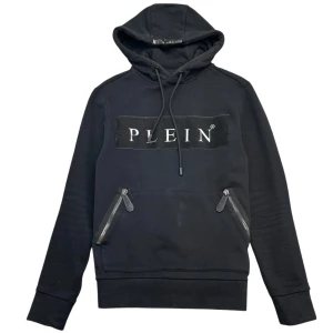 Svart hoodie från Philipp Plein - Snygg svart hoodie från Philipp Plein med logotyp framtill. Den har dragkedjor på fickorna och en justerbar huva med snörning. Perfekt för en stilren look.